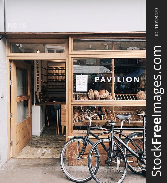 Two Black Bicycles Beside Gray Frame Glass Window