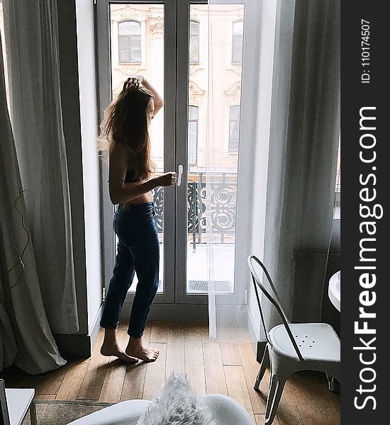 Photo of Woman in Blue Pants Holding Her Hair