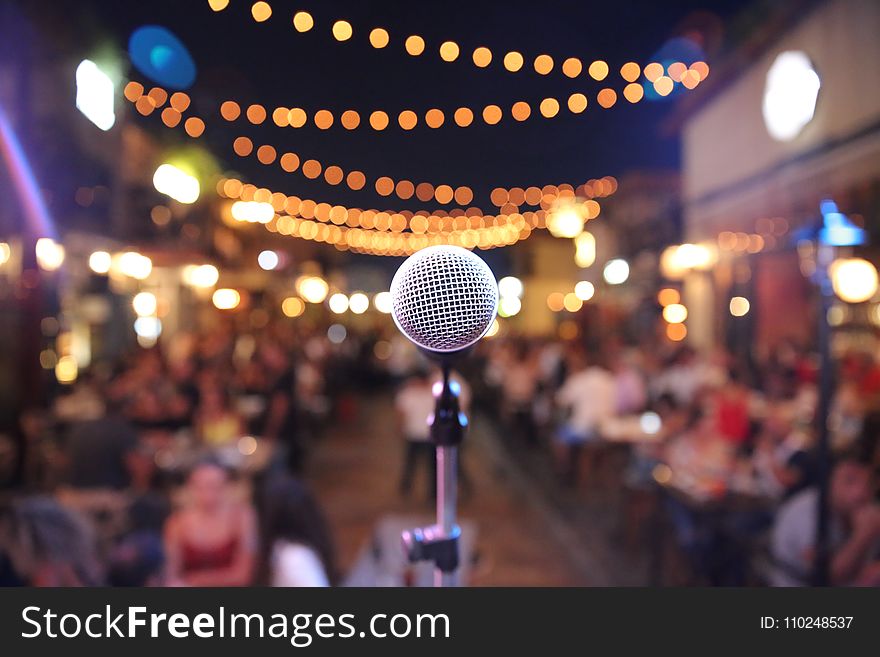 Selective Focus Photo of a Microphone in Front of Audience