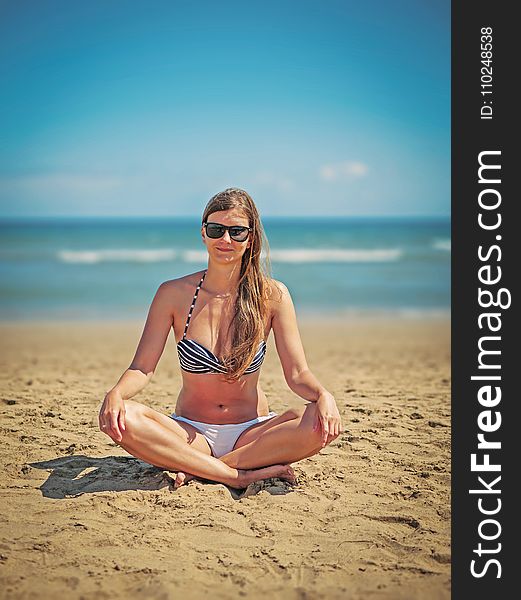 Woman Wearing White-and-black Bikini Sitting on Sand Near Seashore