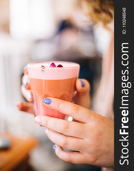 Selective Focus Photo of Person Holding Cup