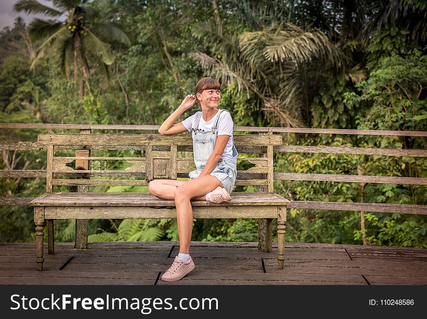 Woman Sitting on Brown Wooden Chair