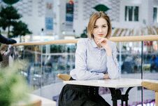 A Young Woman Talking Through The Phone. The Girl Is Sitting At The Table And Makes An Order. Business Woman Stock Images A Young Woman Talking Through The Phone. The Girl Is Sitting At The Table And Makes An Order. Business Woman Stock Images