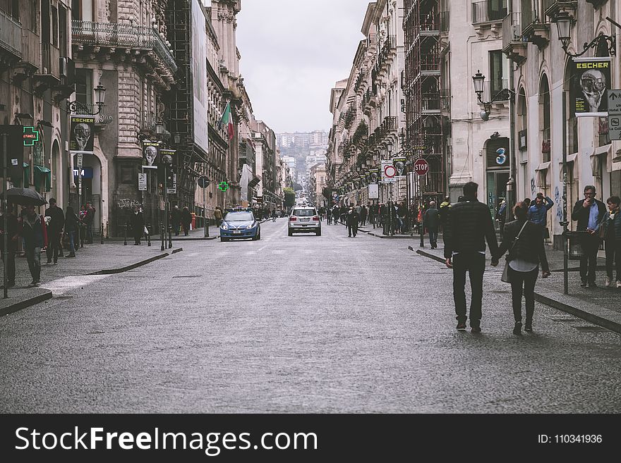 Holding Hand Couple Walking In Street Between Building