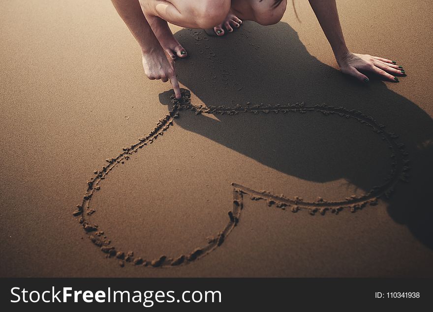 Person Draws Heart on Sand