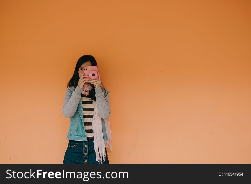Woman in Blue Jacket Holding Pink Fujifilm Instax Camera