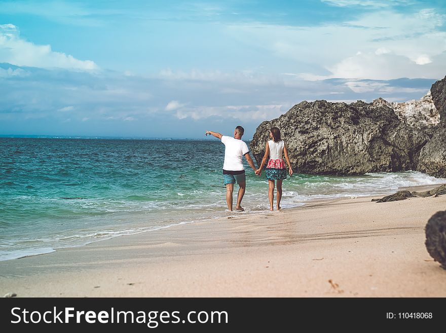 Two Person Walking on Sea Shore