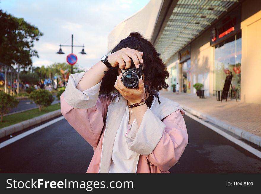 Woman Wearing Pink Coat Holding Dslr Camera