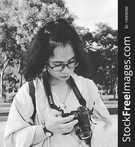 Grayscale Photo of Woman Holding Black Nikon Coolpix Dslr Camera