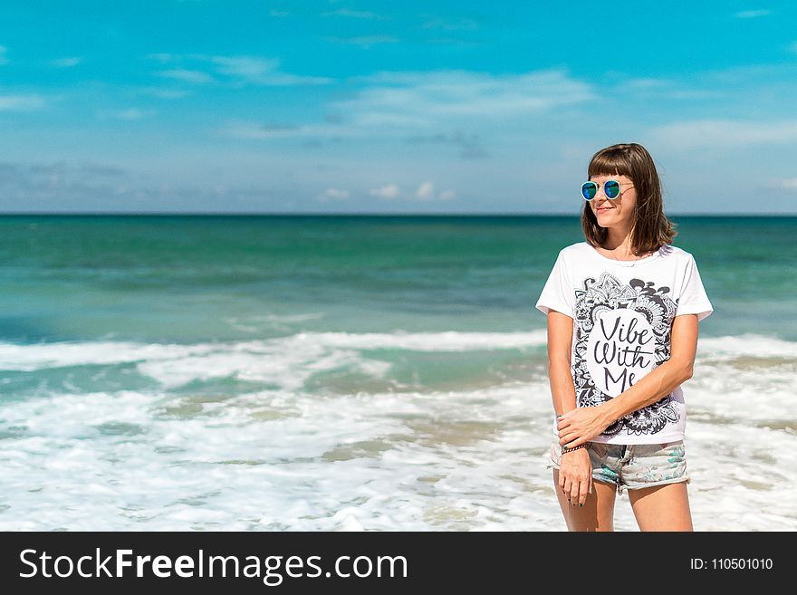 Woman in White Crew-neck Shirt Near Sea Shore