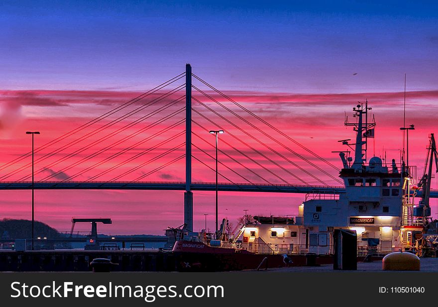Silhouette of a Bridge Under Red Clouds and Blue Sky Taken during Night Time