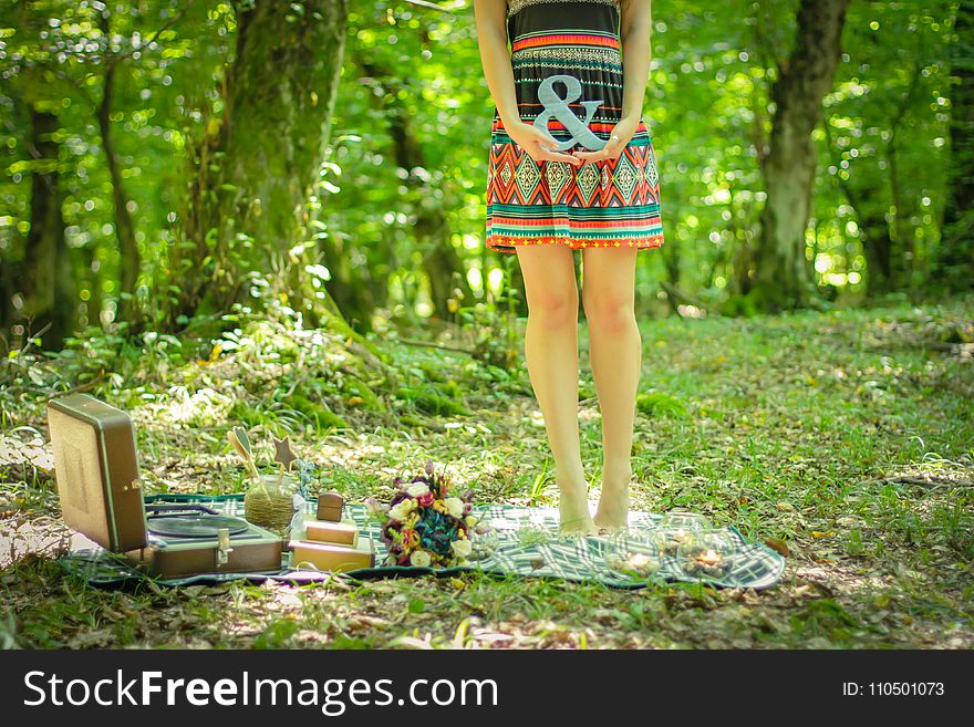 Woman Standing on Picnic Mat Holding Ampersand Lettering