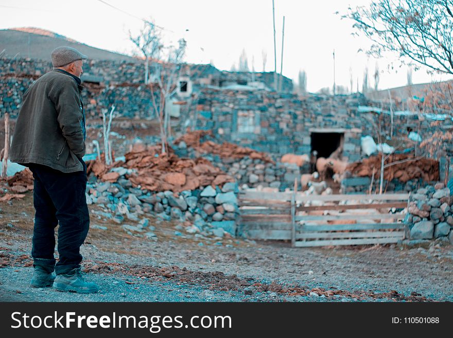 Man In Gray Jacket Standing On Rocks