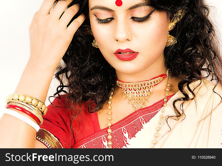 Beautiful indian woman in a red saree and gold jewellry. Beautiful indian woman in a red saree and gold jewellry