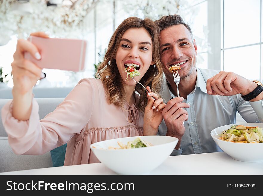 Portrait of a joyful young couple taking a selfie