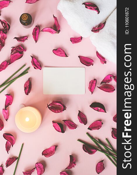 Wellness or spa background; dry petals, candle and incense sticks on pink background with copy space
