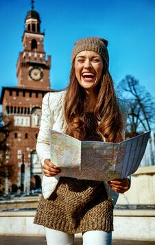 Happy Trendy Tourist Woman In Milan, Italy With Map Royalty Free Stock Photography