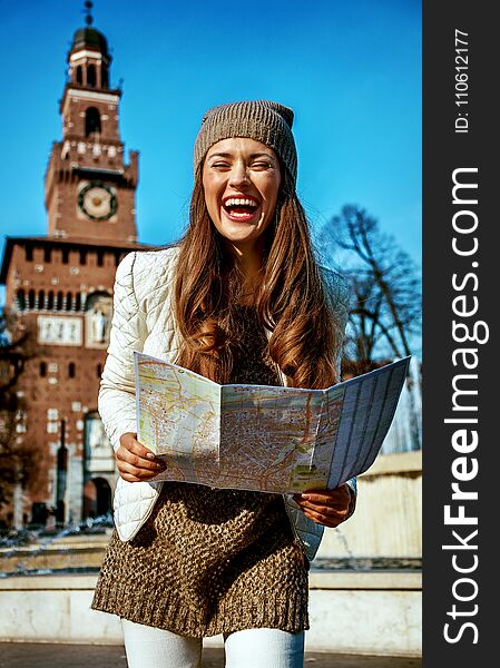 Happy trendy tourist woman in Milan, Italy with map