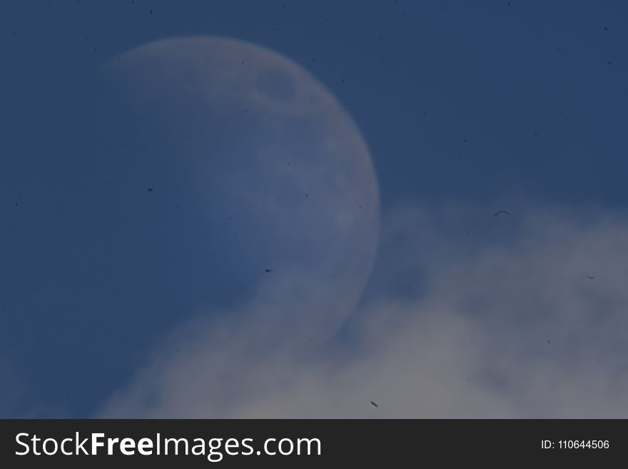 A blue sky with day moon and clouds on a summer`s day. A blue sky with day moon and clouds on a summer`s day.