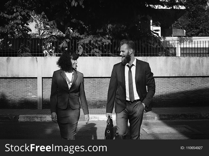 Grayscale Photo of Man and Woman in Formal Suits