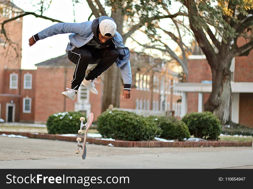 Man Jumps over Skateboard