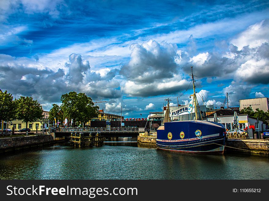 Blue and White Ship in Front of Concrete Structure