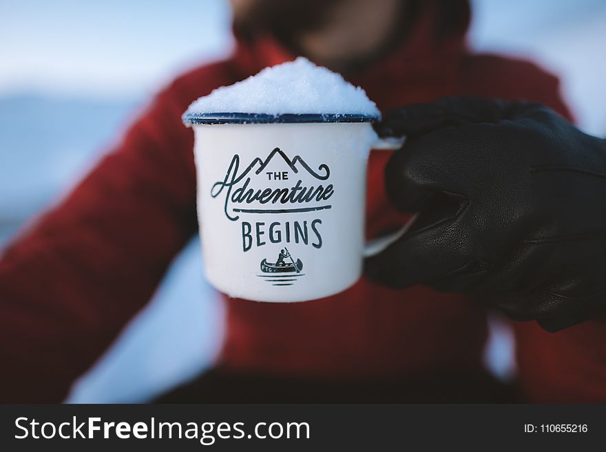 Selective Focus Photography of Person Holding the Adventure Begins Mug