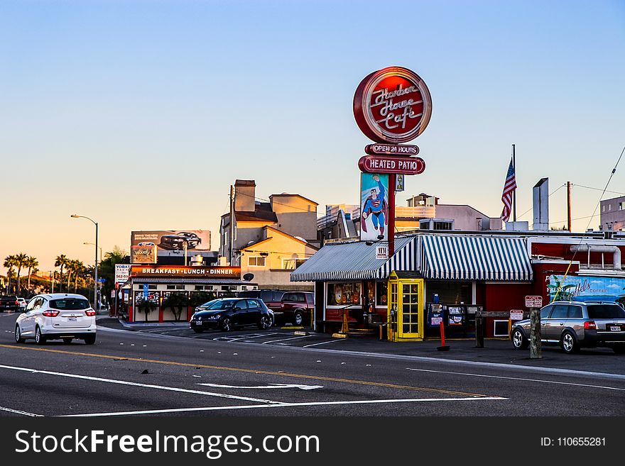 Cafe Signage Near Yellow Telephone Booth And Black Car