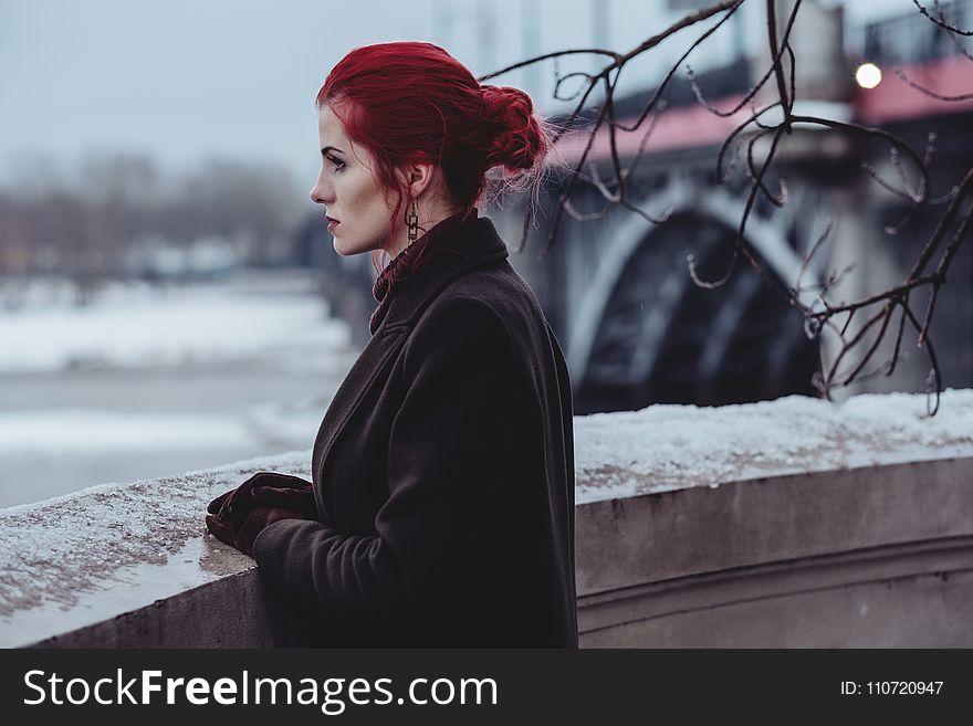 Woman Wearing Black Coat Standing In-front of Balcony