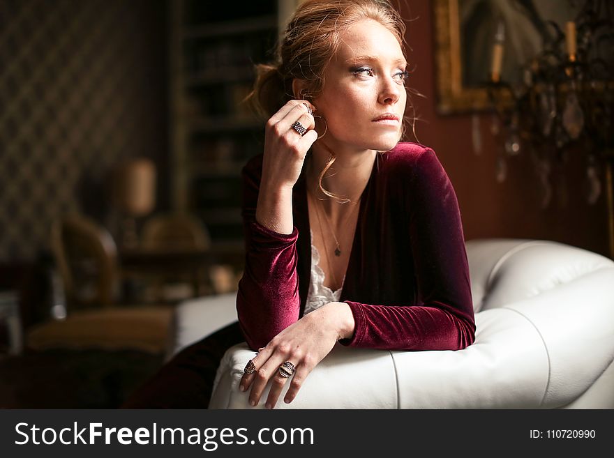 Selective Focus Photo of a Woman Sitting on White Leather Sofa