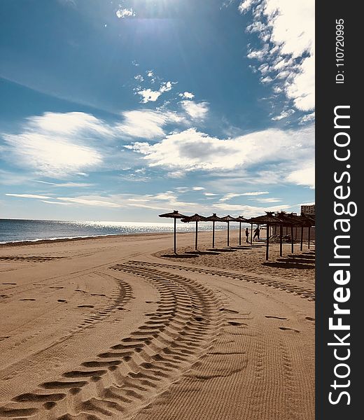 Brown Sand Near Seashore Under Cloudy Sky