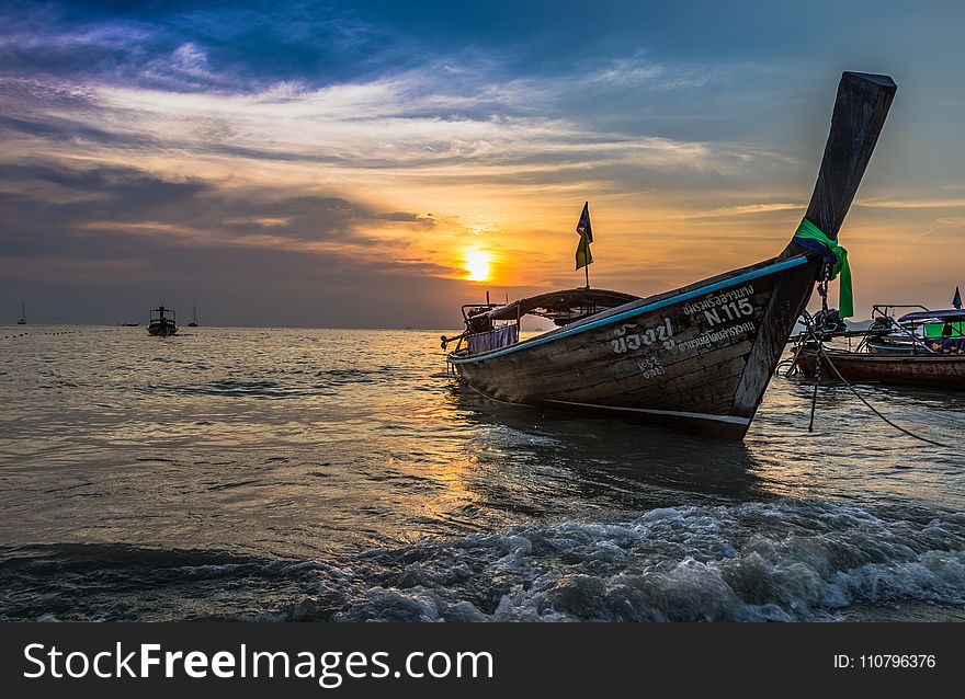 Photo of Brown Boat at Sea during Golden Hour