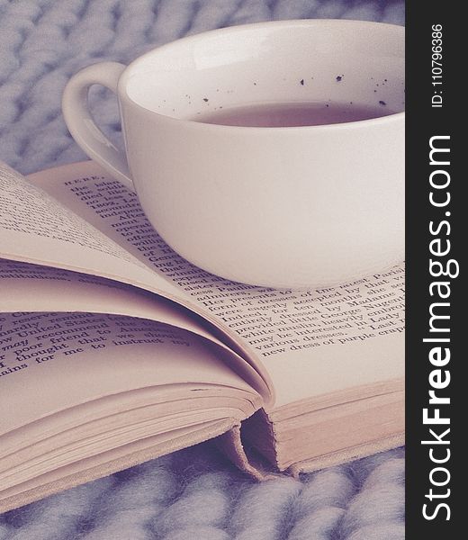 White Ceramic Cup on Top of Book