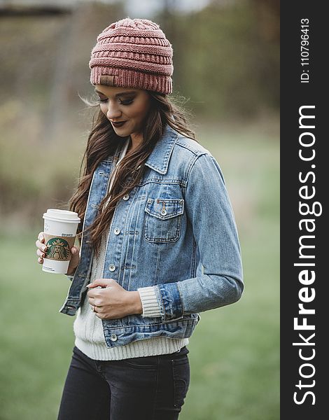 Woman Wearing Blue Denim Jacket and Pink Knit Cap Holding Starbucks Coffee