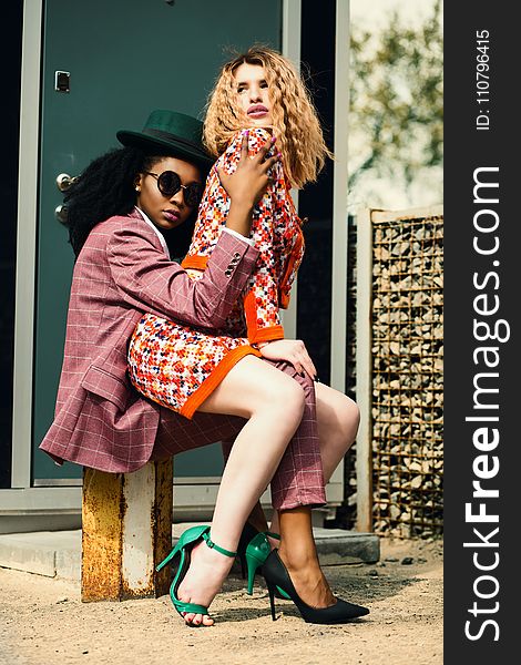 Two Ladies Sitting on Metal Bench