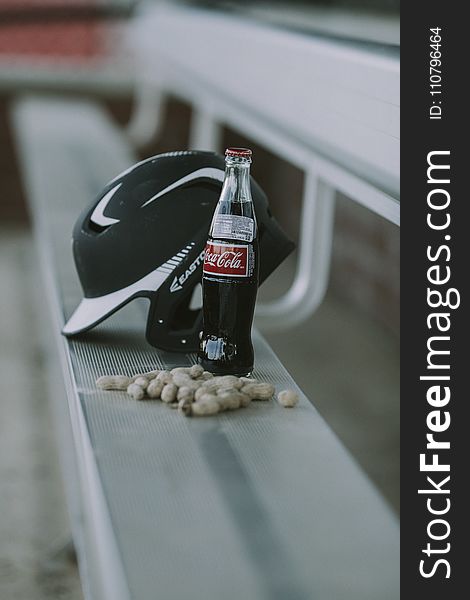 Coca-cola Bottle Beside Black Easton Batting Helmet