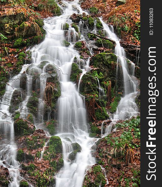 A little waterfall(cascade) in the mountains , shot at a slow shutter speed.