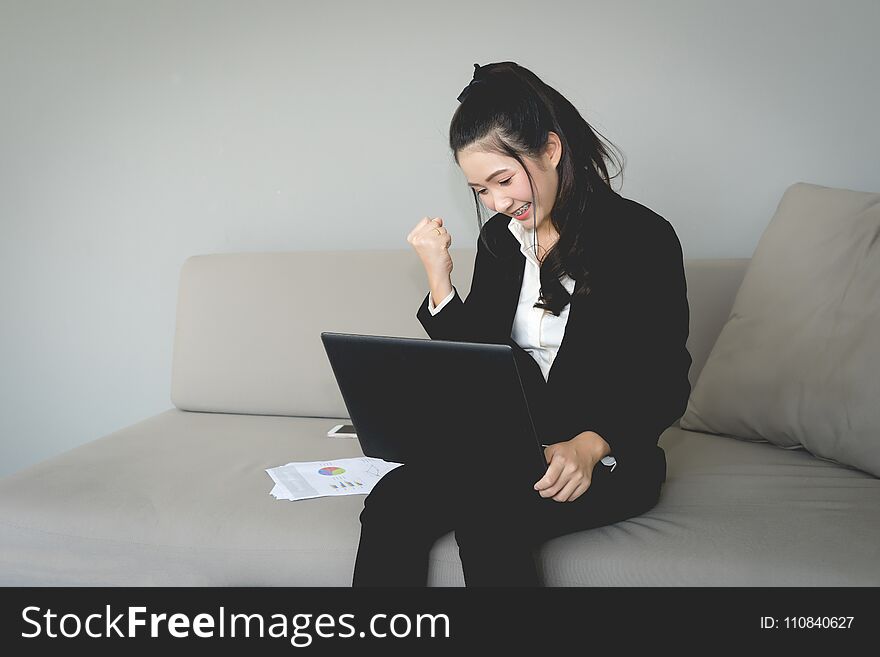 Excited happy young woman with fists up, Air punch. Business girl in black suit punching in the air. victory and success concept.