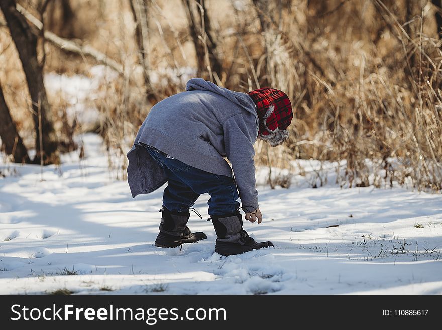 Shallow Focus Photography Kid Wearing Gray Jacket on Snow Covered Field