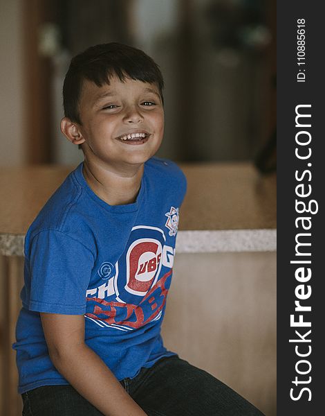 Person Taking Photo of Boy in Blue Chicago Cubs Crew-neck T-shirt in Tilt Shift Photography