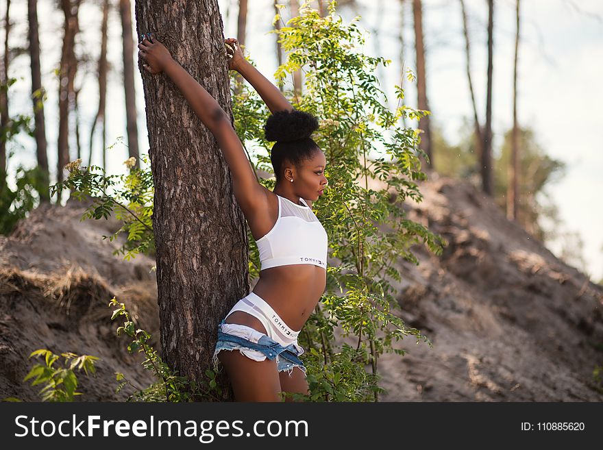 Woman Wearing White Sports Bra Holding Tree