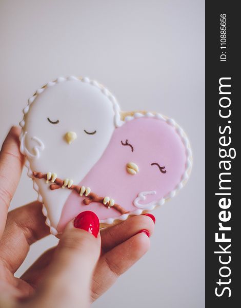 Person Holding White and Pink Birds Ornament