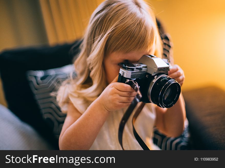 Shallow Focus Photography of Girl Holding a Black and Silver Dslr Camera