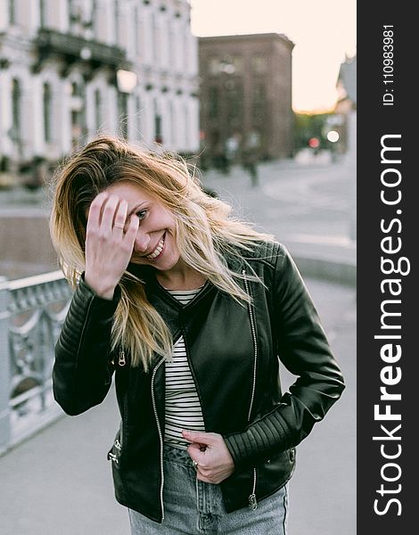 Photo of Woman Wearing Black Zip-up Leather Jacket and White and Black Striped Shirt