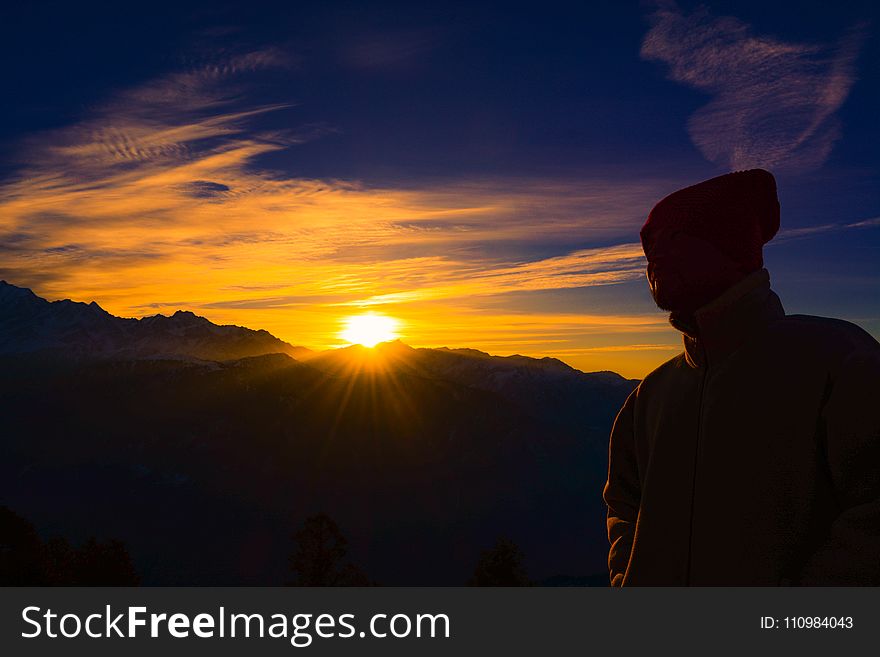Silhouette of Person Near Mountain during Golden Hour
