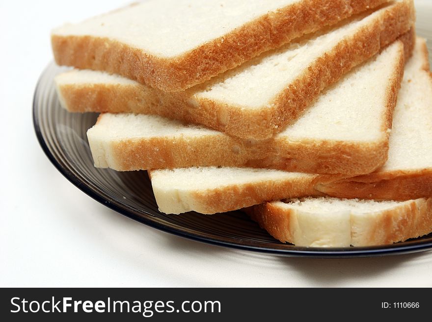 Slices of White bread on a plate against a white background