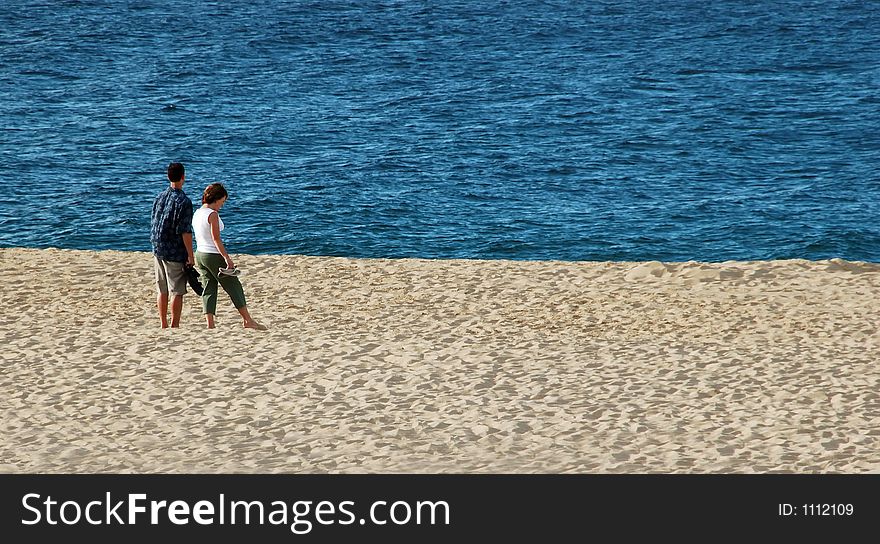 Couple Standing on Beach with Blue Blue Ocean