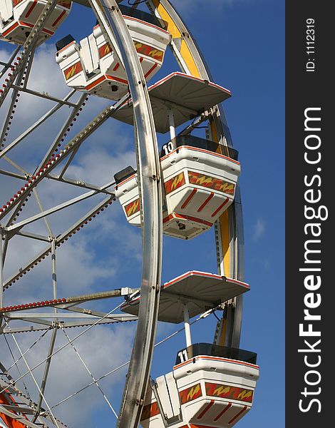 Ferris wheel against blue cloudy sky