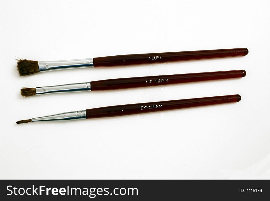A set of three makeup brushes.