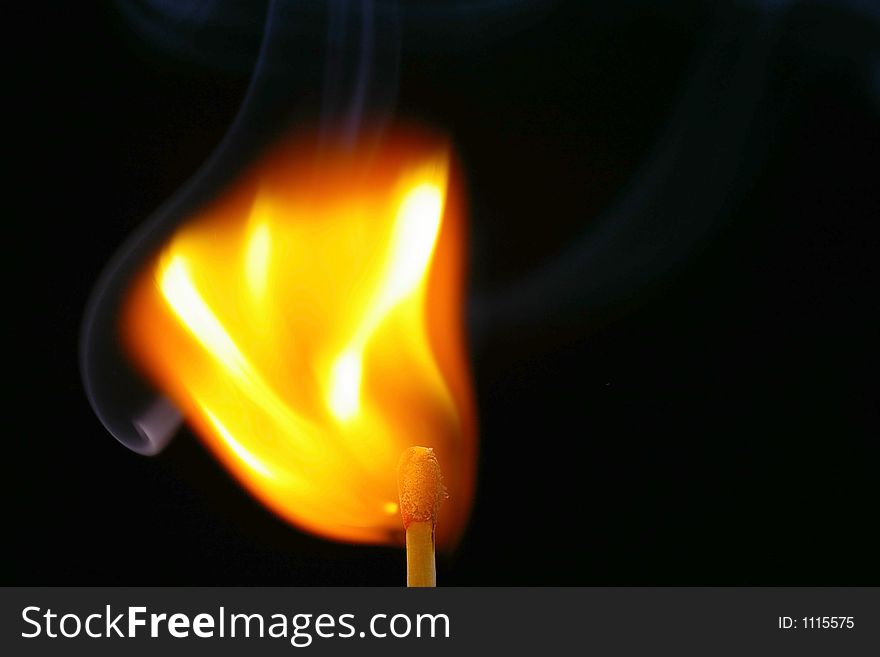 Closeup of a red-tipped wooden match stick at ignition.  Red, orange, yellow, and white flame.  Black background. Closeup of a red-tipped wooden match stick at ignition.  Red, orange, yellow, and white flame.  Black background.